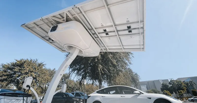 Electric car charging under a modern solar panel station, showcasing clean energy technology.