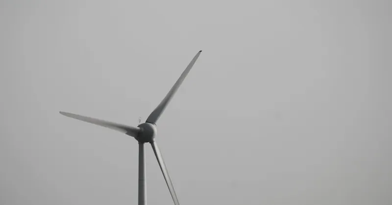 A single wind turbine set against a cloudy sky, emphasizing clean energy