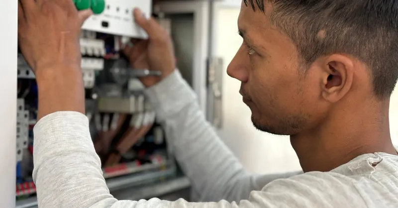 Focused electrician adjusting circuit breaker panel. Technology and skill in action.