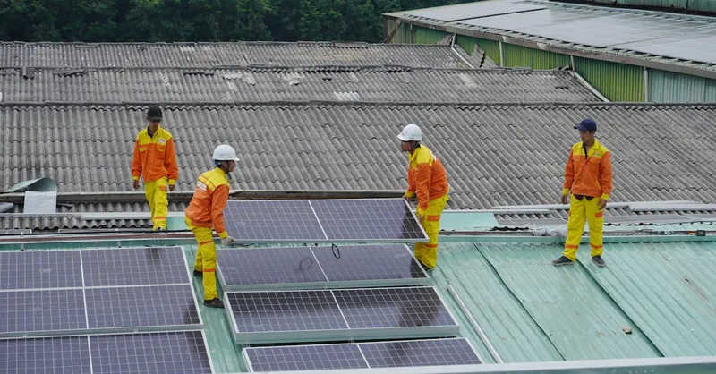 Workers installing solar panels on a roof for sustainable energy solutions.