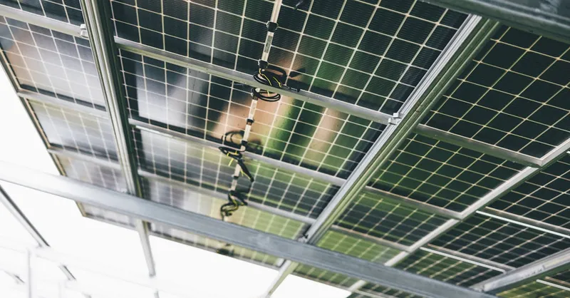 Close-up of solar panels being installed outdoors with technicians visible.