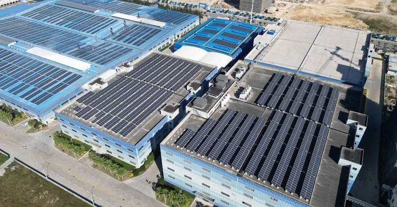 Aerial shot of industrial buildings with solar panels harnessing renewable energy.