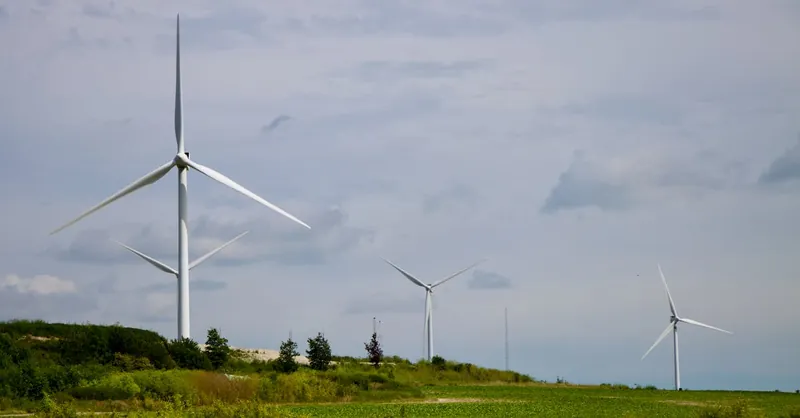 Wind turbines generating clean energy in a green field, symbolizing sustainable power solutions.