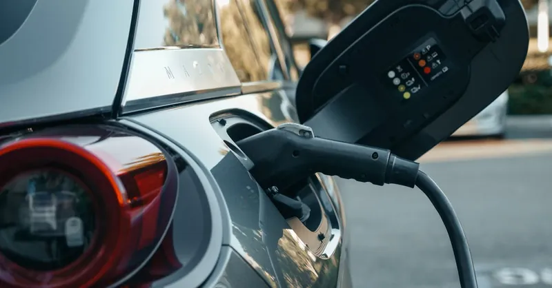 Close-up of an electric vehicle being charged, highlighting modern clean energy technology.